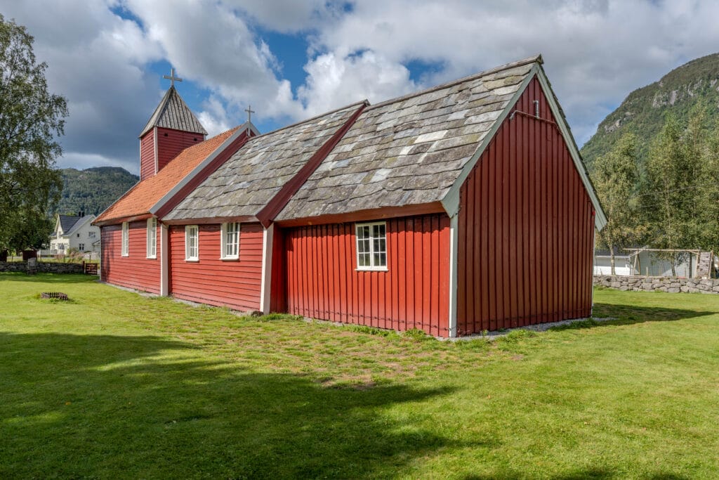 Gamal raud kyrkje med grasplen